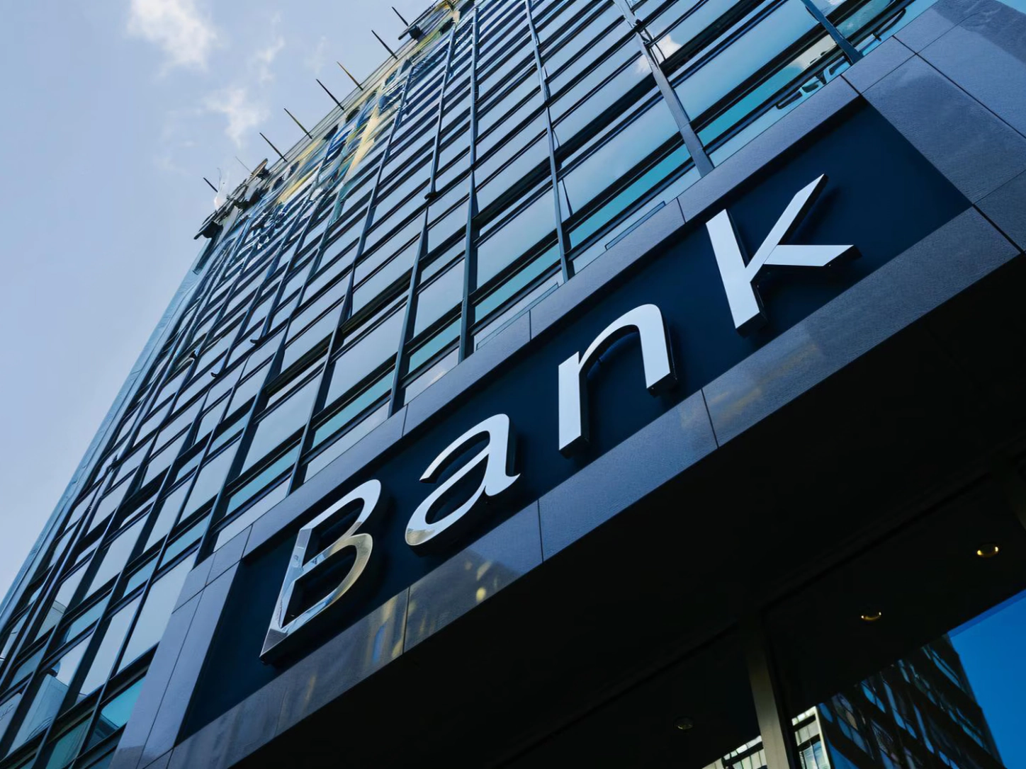 L’insegna «Bank» sulla facciata di un grattacielo con vetrate, vista dal basso